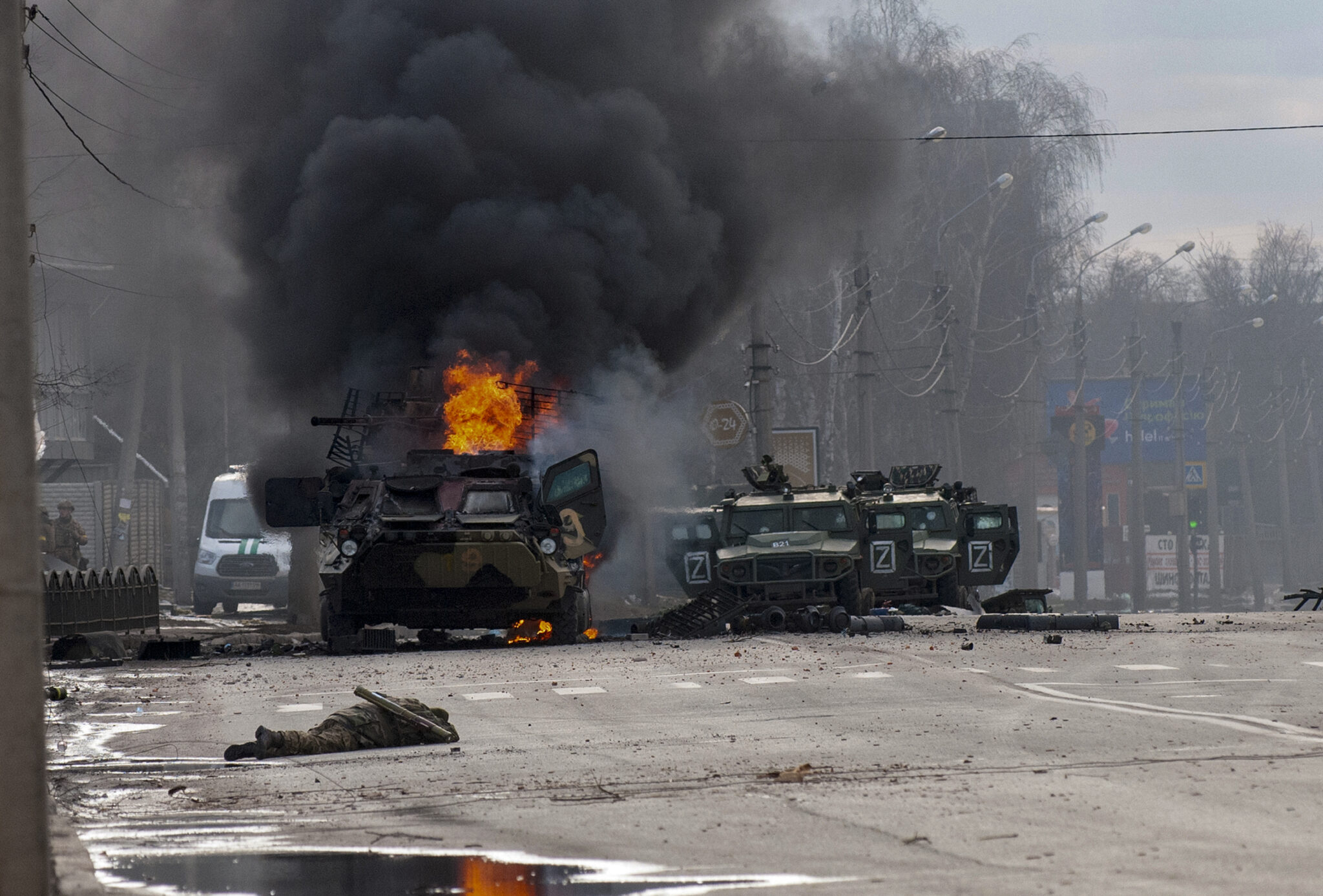 Горящий бронетранспортер и поврежденные легкие грузовые автомобили стоят брошенными после боев в Харькове. Фото Marienko Andrew/AP Photo/Scanpix/LETA